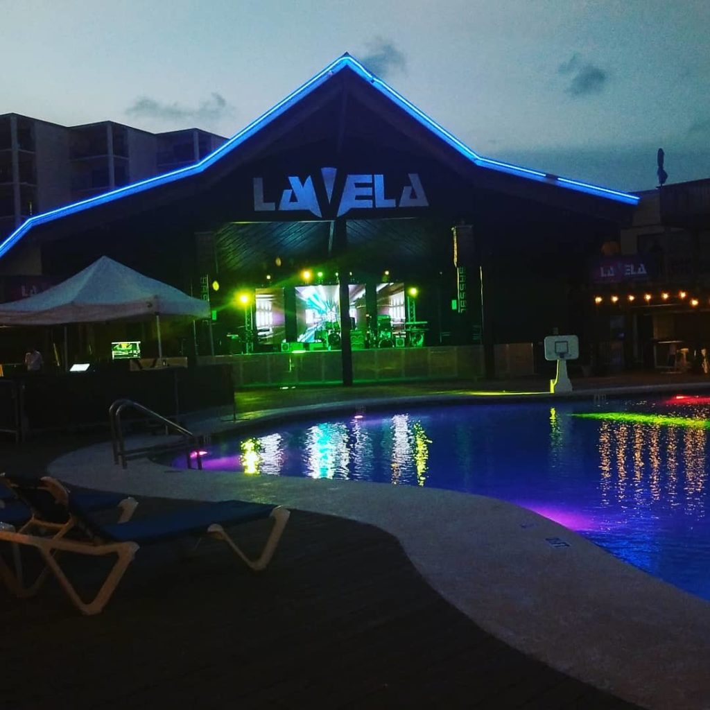 a night club with a pool and strobing lights on the stage