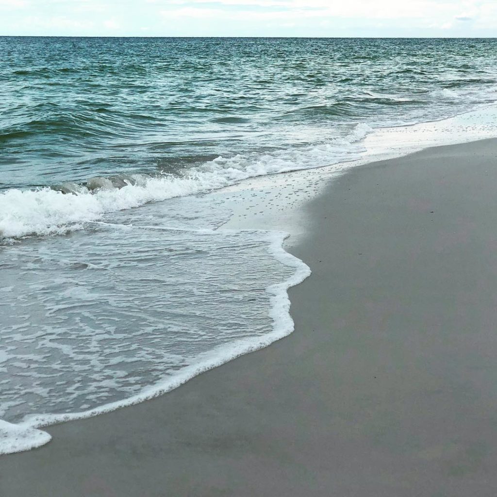 calm waves washing up onto the shore, beach day