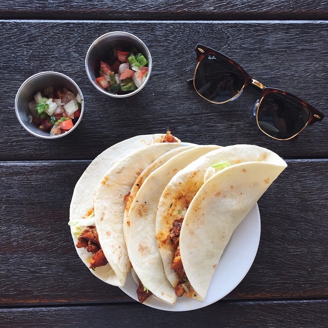 three flour tacos on a plate with a side-of extra topic.