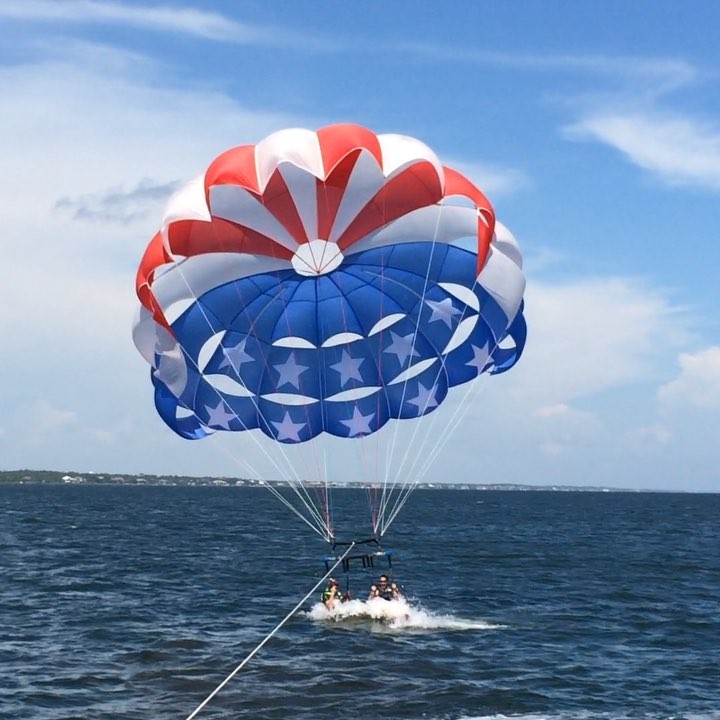 two people parasailing American Flag themed parasailing kite at Radical Rides 