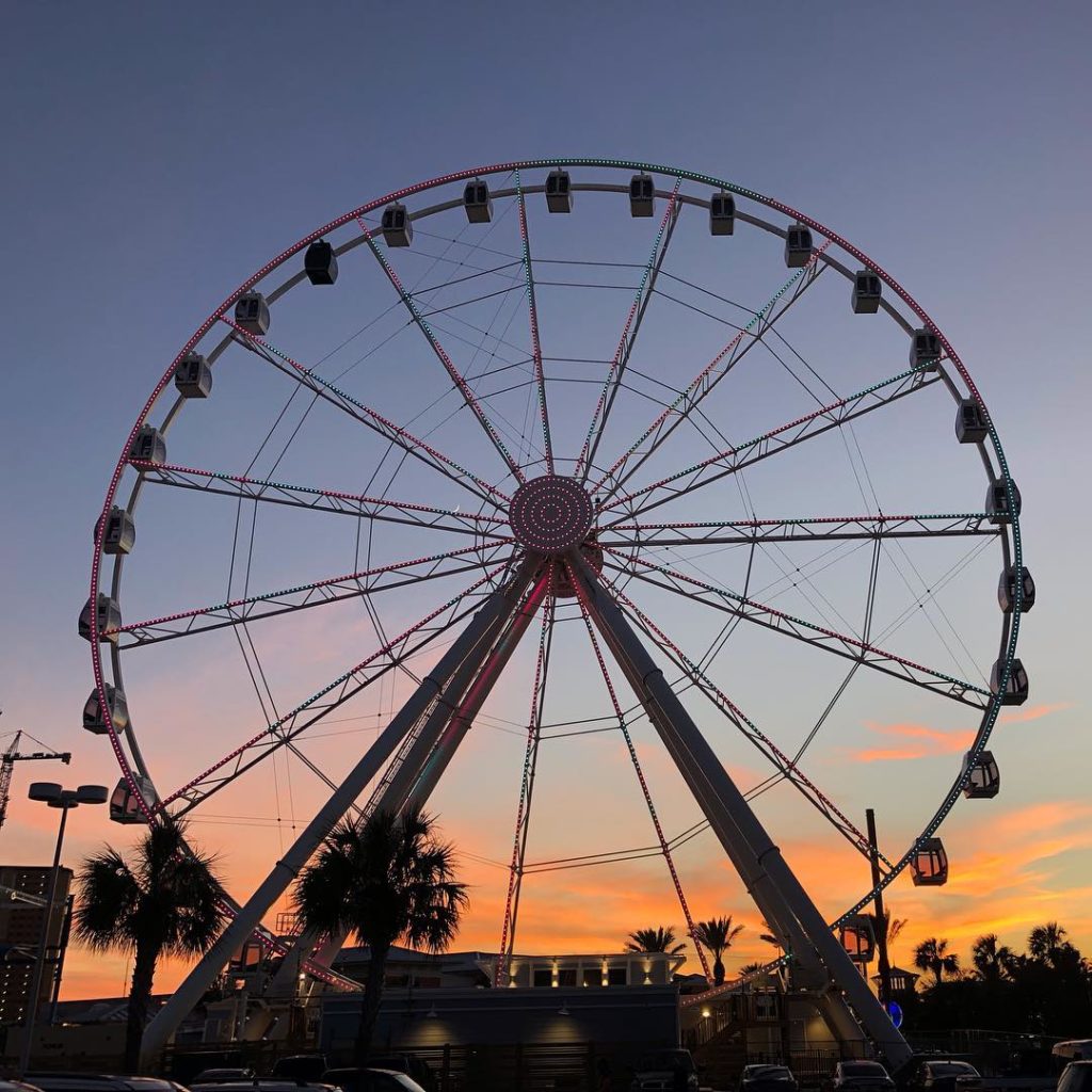a giant ferris wheel with views of the sunset in the back ground at Panama City Beach SkyWheel