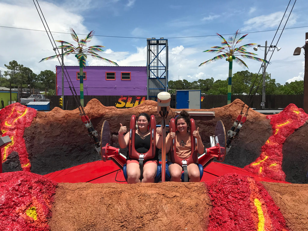 two girl buckled in on a slingshot ride