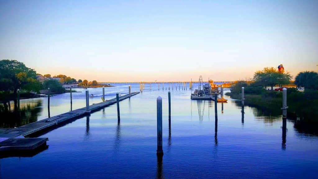 view of a long boat dock on the water during the sunset