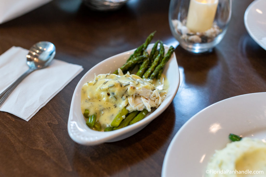 a small plate of asparagus with sauce on top