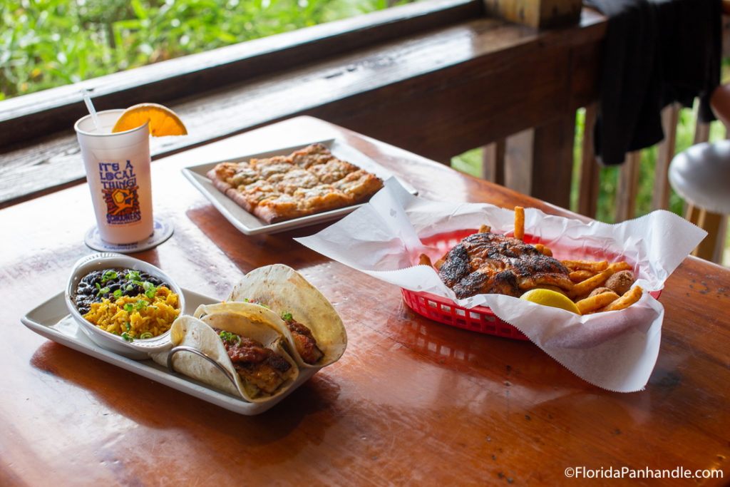 tacos with a side o f rice and beams next to pizza and grilled fish on a table at Schooner's in Panama City Beach