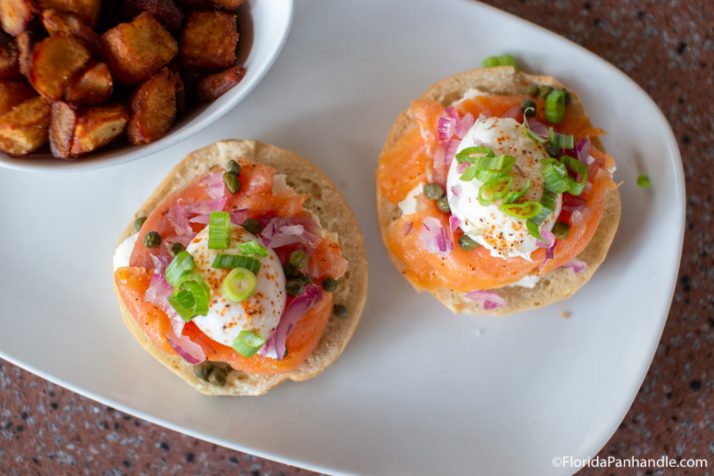 a plate of fresh salmon on a bagel with a poached egg on top at Another Broken Egg Cafe