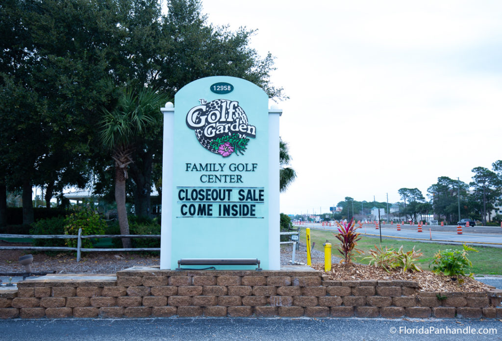 a baby blue turquoise sign with black letters at The Golf Garden