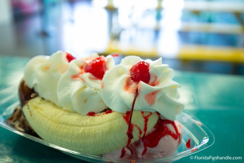 a banana split with whipped cream, cherries and strawberry drizzle on top at Simple and Sweet in Destin, Florida