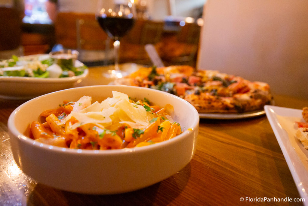 a bowl of pasta with shaved parmesan cheese on top