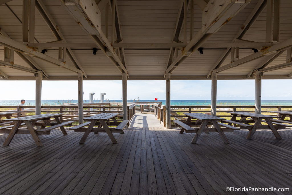 a covered pavilion area with picnic tables just a couple steps from the beach