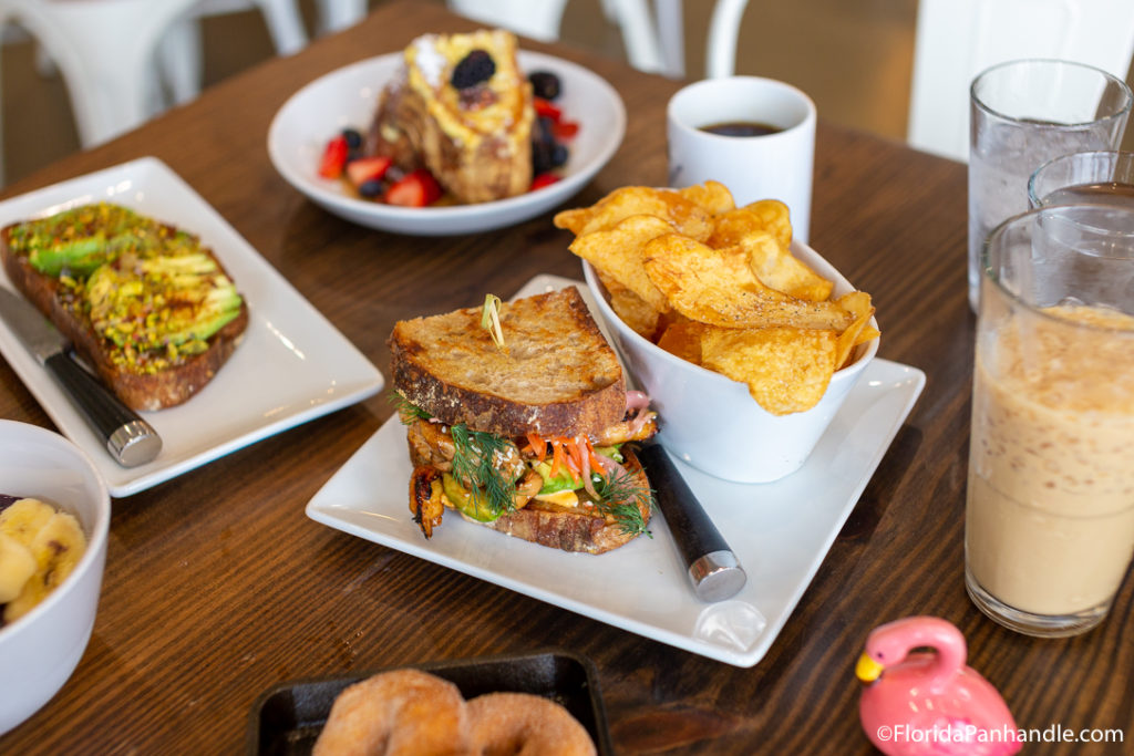  a breakfast sandwich with side of potato chips and an iced coffee at 2 Birds Coffee & Cafe in Destin, Florida