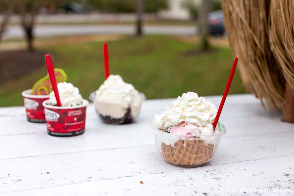 a cup of ice cream with a waffle bowl and whipped cream on top