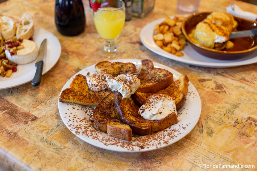 a plate of french toast with whipped cream and cinnamon on top