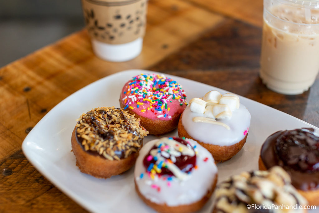 donut shops in destin, a variety of colorfully decorated donuts, Destination Little Donuts