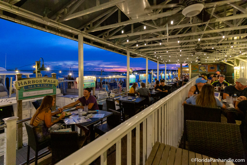 a covered outdoor dining area alongside a marina, beachside restaurant in destin