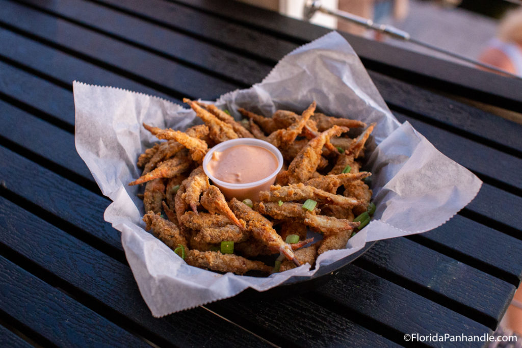 a basket of fried shrimp with a dipping sauce in the middle