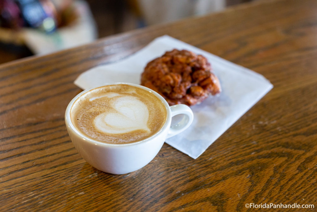 coffee cup with coffee and heart design milk froth with muffin in the background at Cappricio Cafe