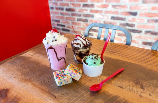 a confetti fudge bar, a mint chocolate chip cup of ice cream, a chocolatey ice cream sunday, and a strawberry milkshake with whipped cream on top