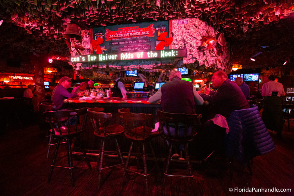 a hightop bar area with dollar bills surrounding and covering every inch of the wall and ceiling