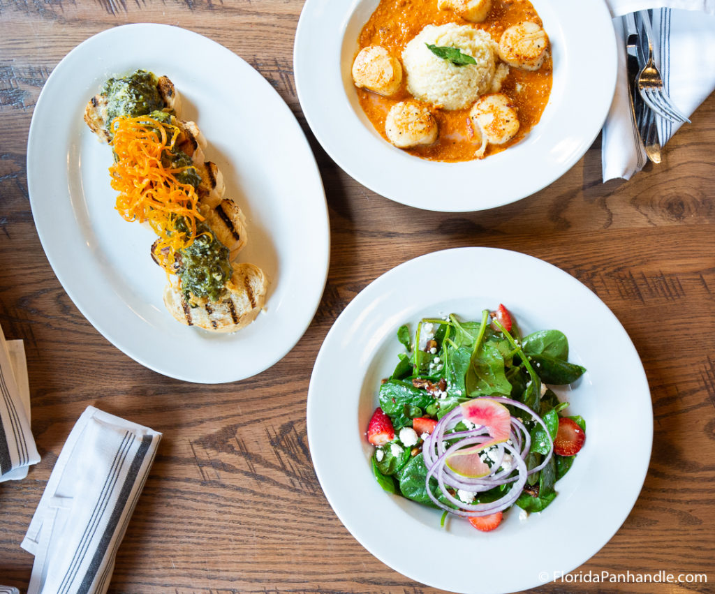 a plate of fresh salad, a plate of scallops and rice at Slick Lips