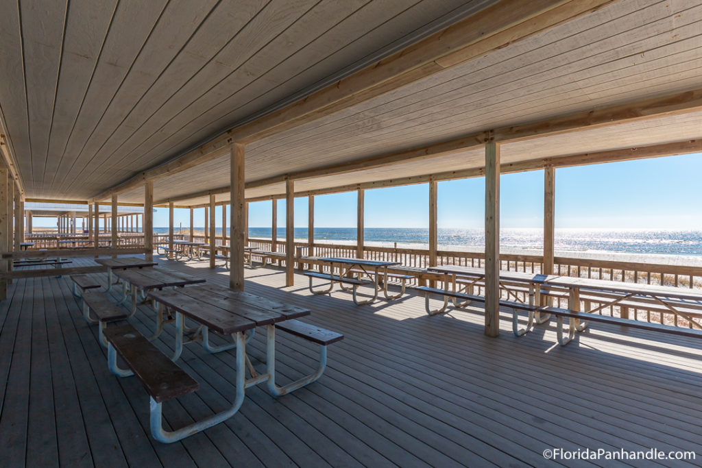 picnic tables under a sheltered area on the beach