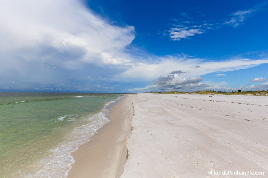 an empty beach with turquoise waters during the day 