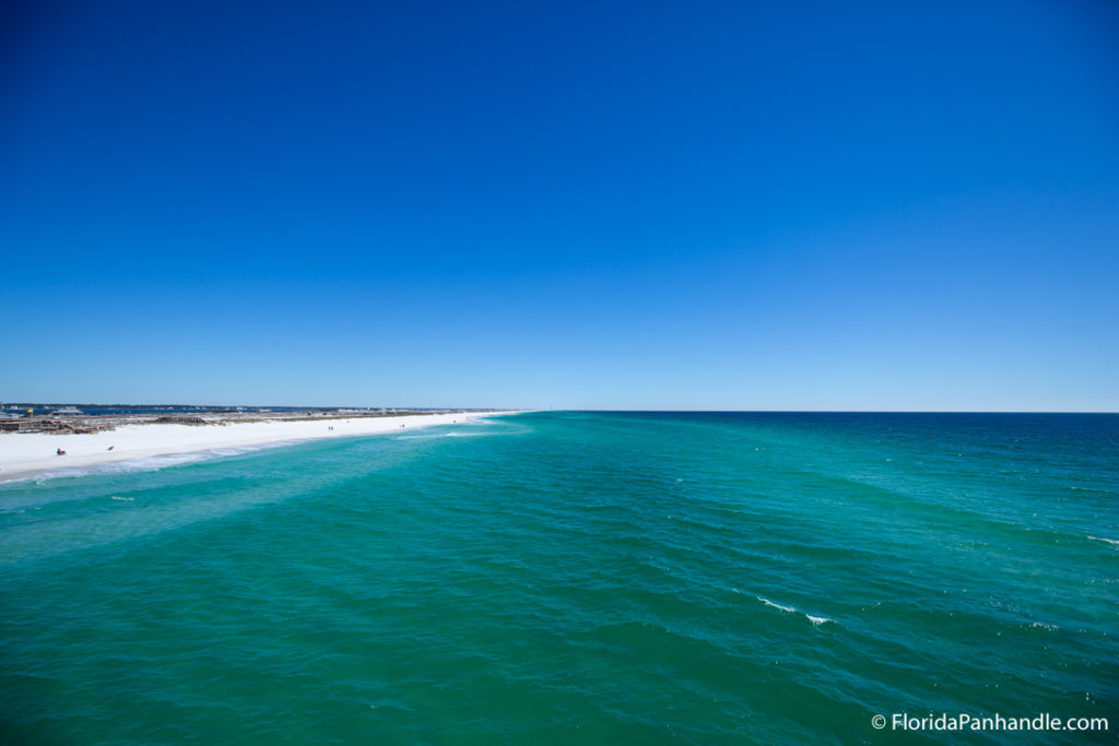 a view of the beach from the ocean on a sunny day with clear bright blue skies