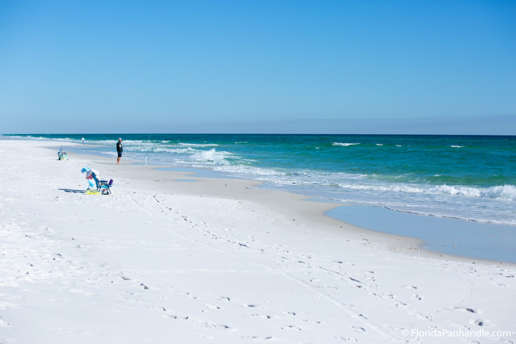 one person at and empty beach standing at the shoreline looking into the abyss of the ocean at Opal Beach In Florida