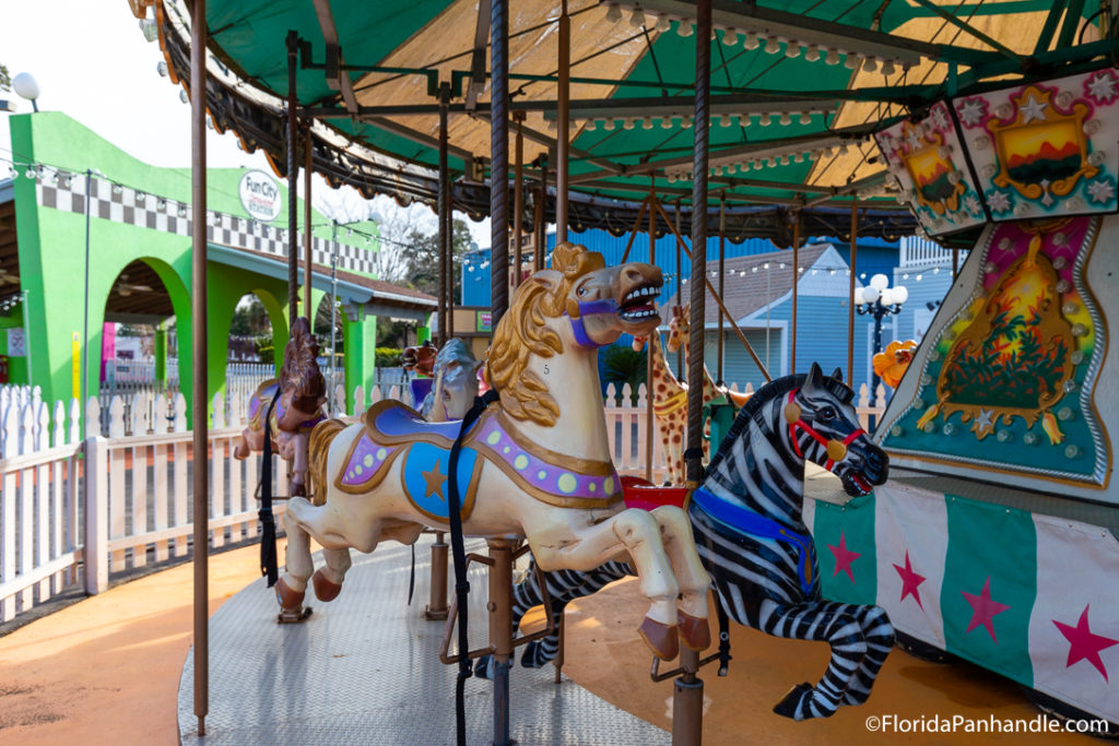 Colorful horse next to a zebra on a carousel at Sam's Fun City  