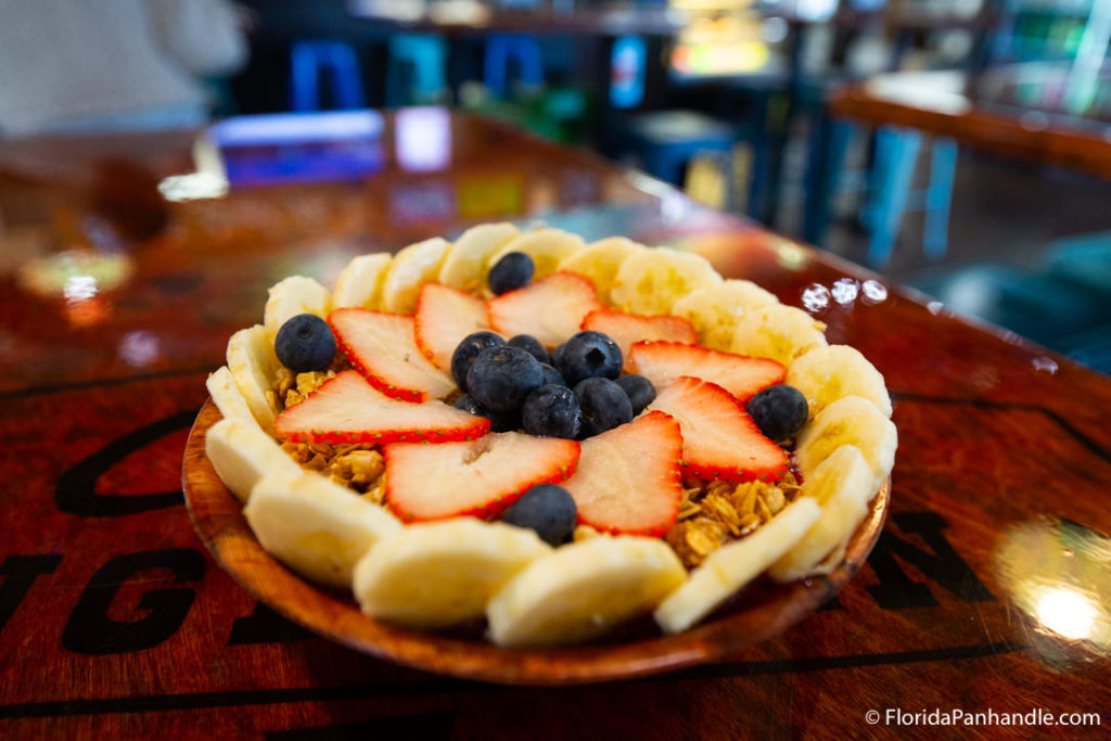 a bowl of banana's, blueberries, strawberries, and granola