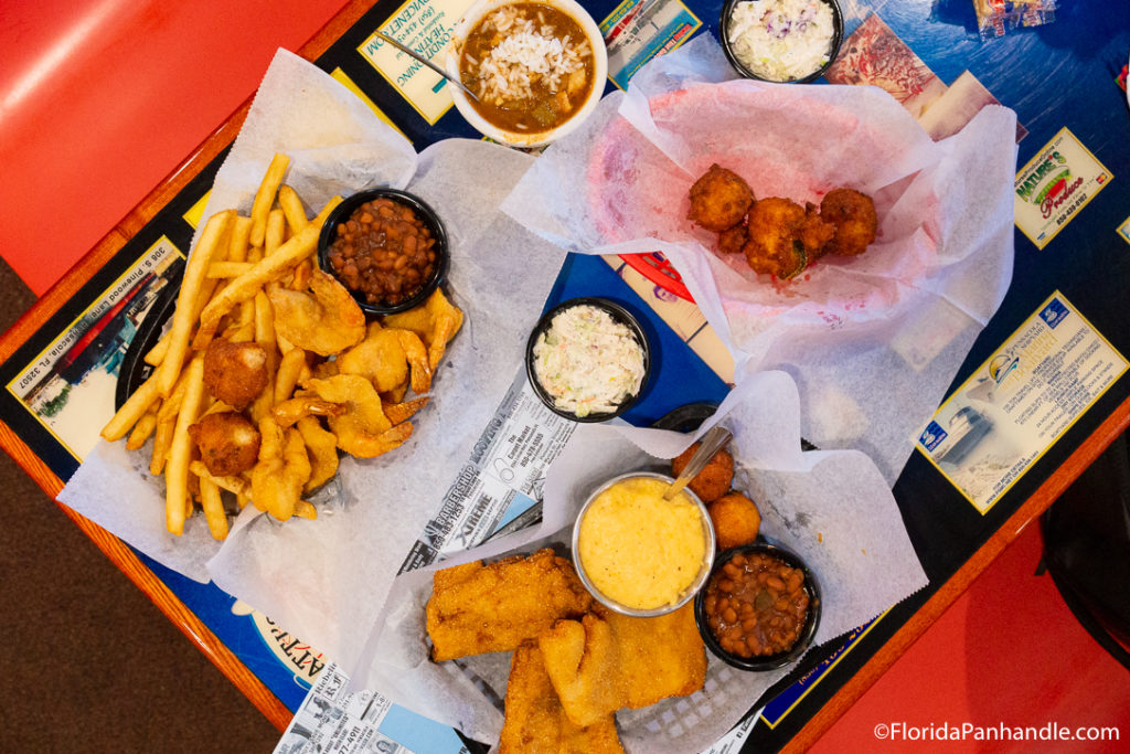 Plate of fish and fired fish with a side of beans, fries and coleslaw at Captain Joey Pattie's Seafood in Pensacola Beach Florida