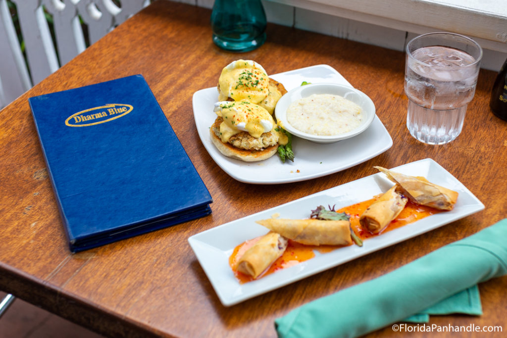 plate of eggs Benedict with gravy on the side and a plate of lightly fried spring rolls as well at Dharma Blue