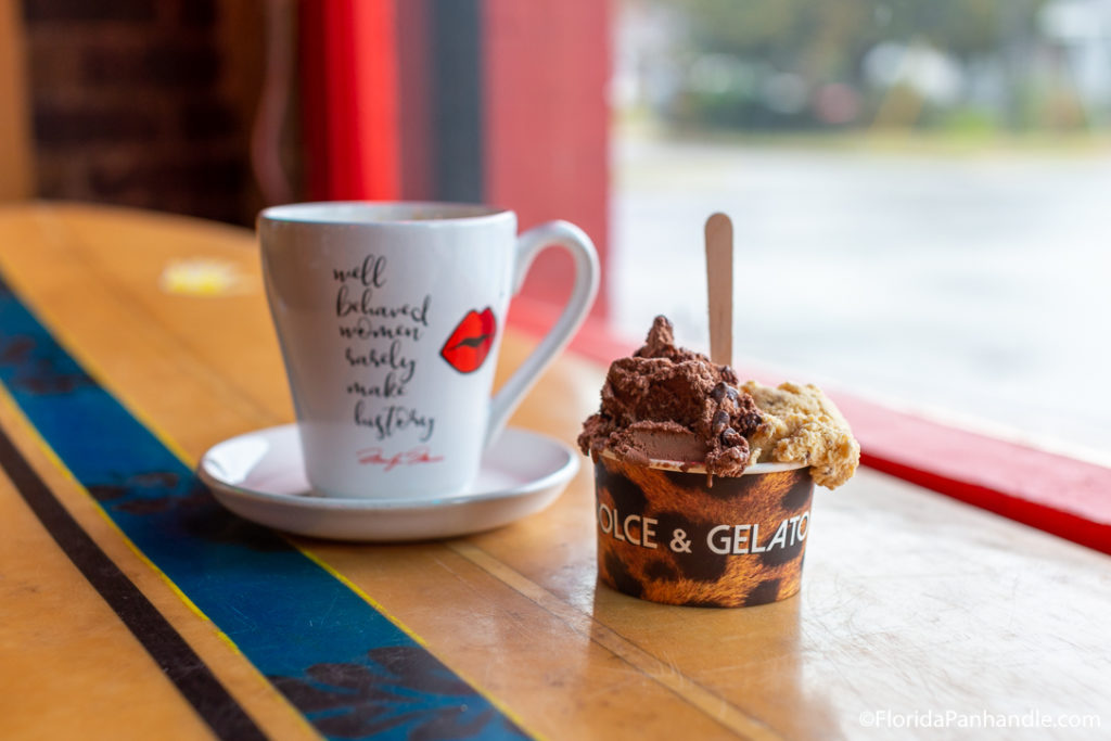 a cup of chocolate gelato with a cup of coffee on the side