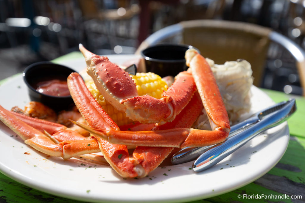 plate of boiled crab legs with a side of corn at The Frisky Dolphin in Pensacola Beach Florida