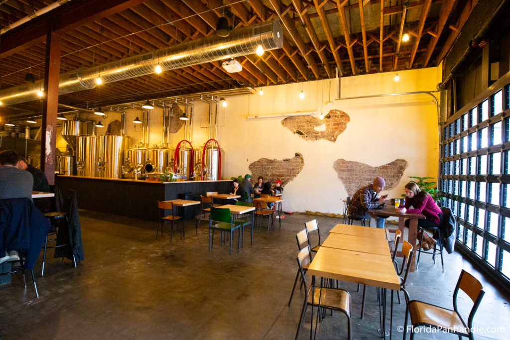 wooden tables with people sitting at them at a pensacola brewery 