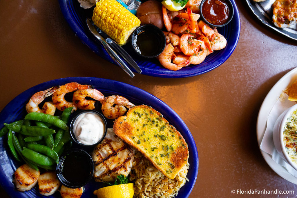 a seafood platter with grilled fish, shrimp and scallops with a side of wild rice, edamame, and garlic toast at Peg Leg Pete's