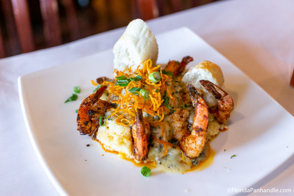 plate of cajun shrimp on a bed of mashed potatoes with a side bread at the Fish House