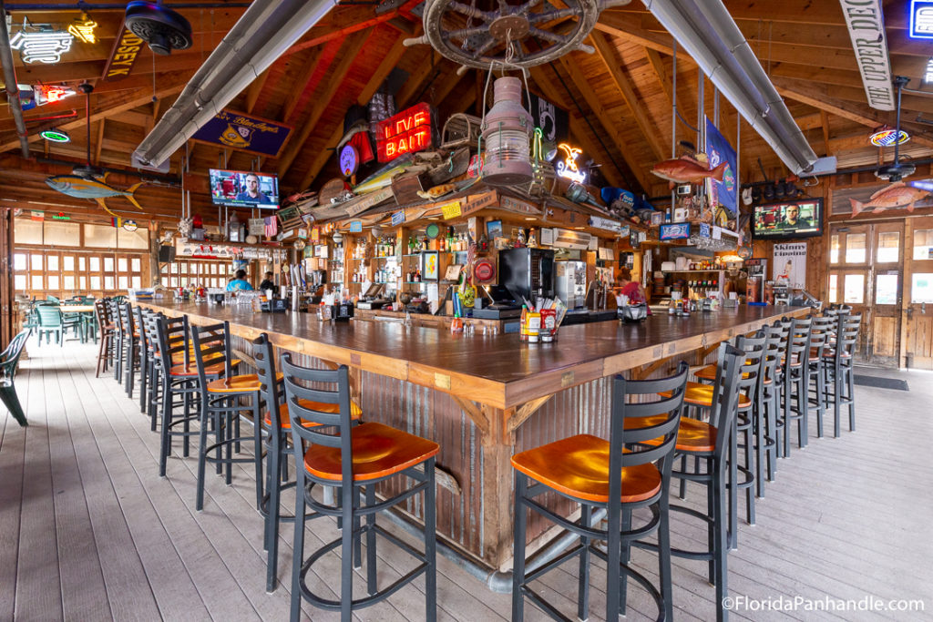 a wooden bar with hightop chairs at The Oar House in Pensacola Florida