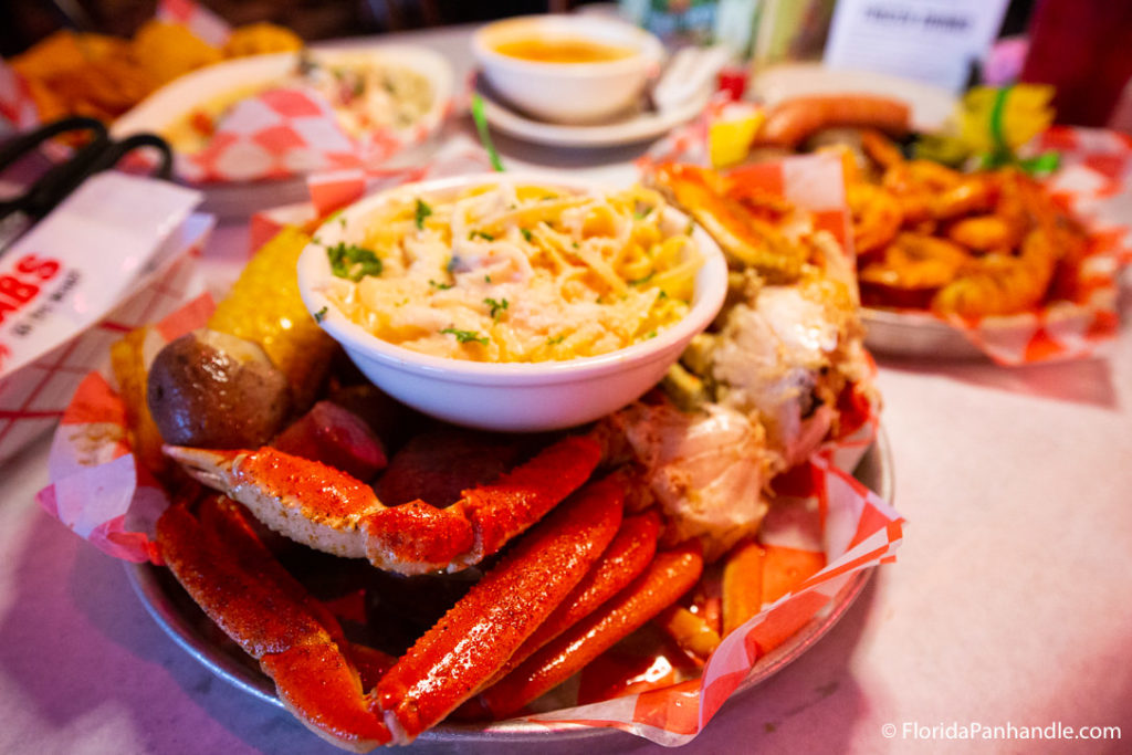 a seafood broil with crab legs, corn, potatoes, and a side of butter dipping sauce at Crabs on the Beach