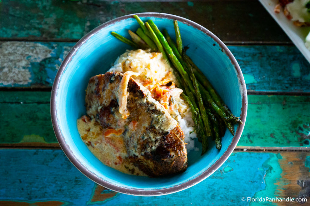 light blue bowl with asparagus and chicken inside