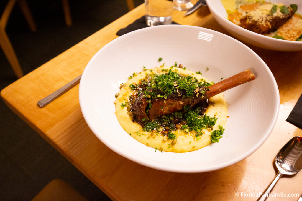 a plate of mashed potato with a lamb chop on top with cilantro pesto on top at Restaurant Iron
