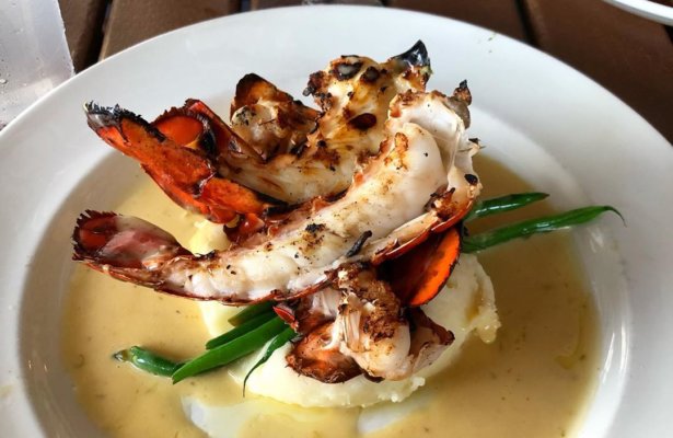 lobster tail on top of mashed potatoes and green beans at pensacola seafood spot