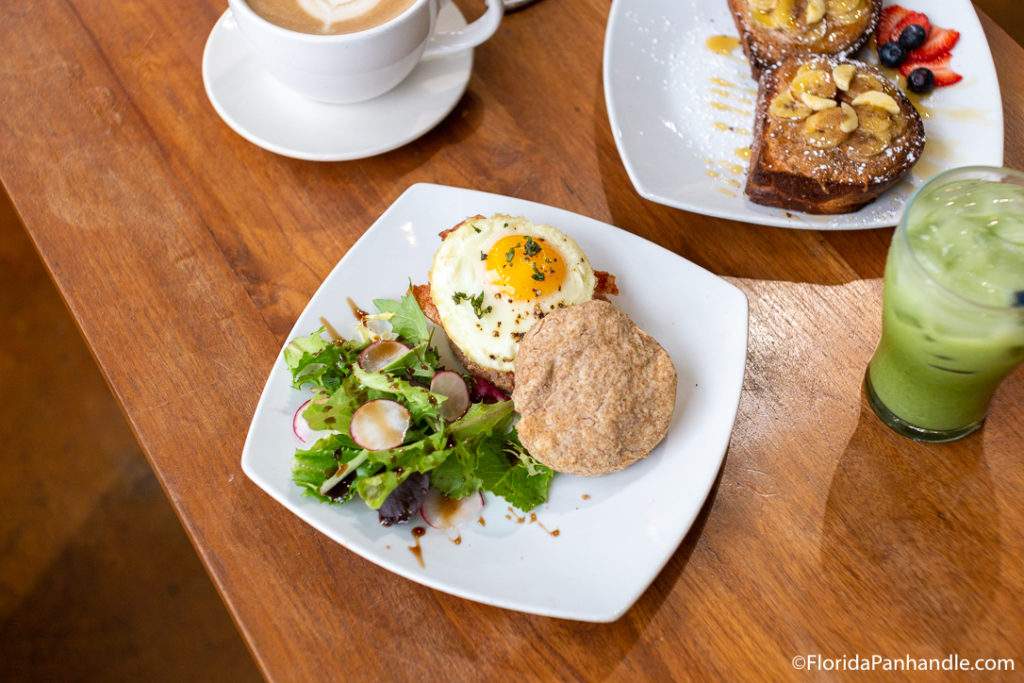 an egg and bacon breakfast sandwich  with a side salad at Amavida Coffee and Tea in Panama City Beach Florida