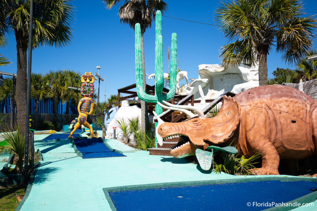 a rhino and other large figures at a mini golf course in pcb