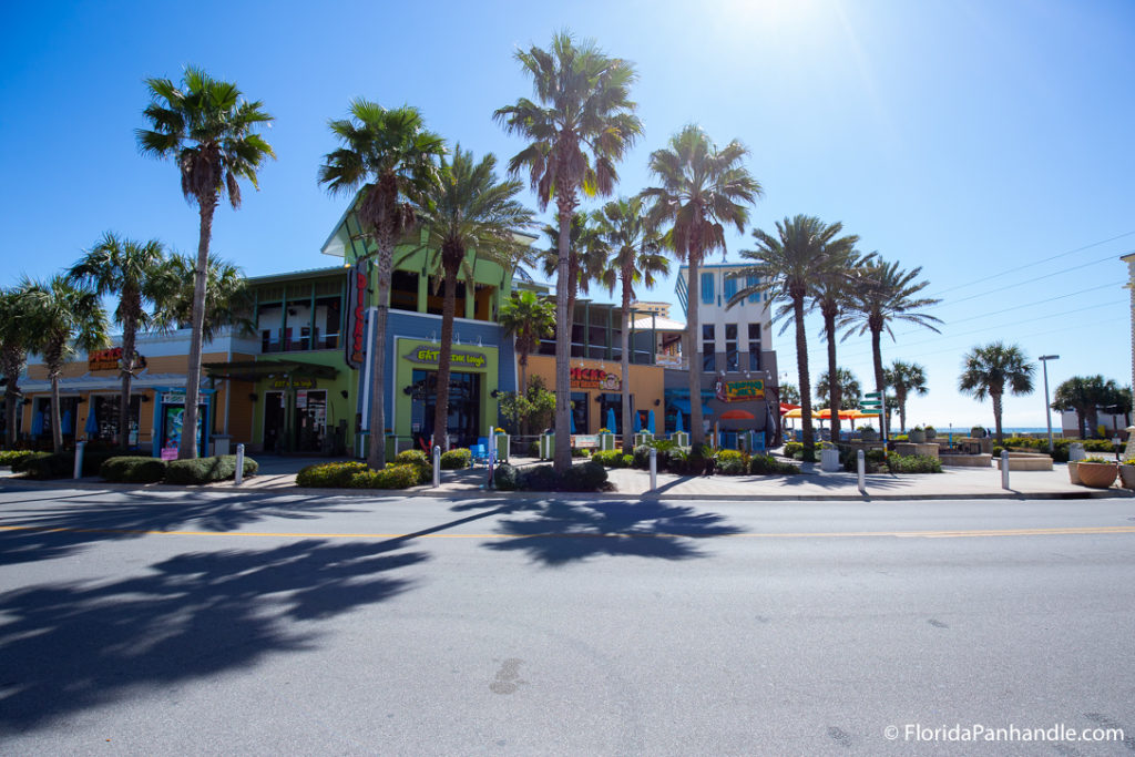 colorful green orange and white shopping stores with palm trees outside at Pier Park in Panama City Beach