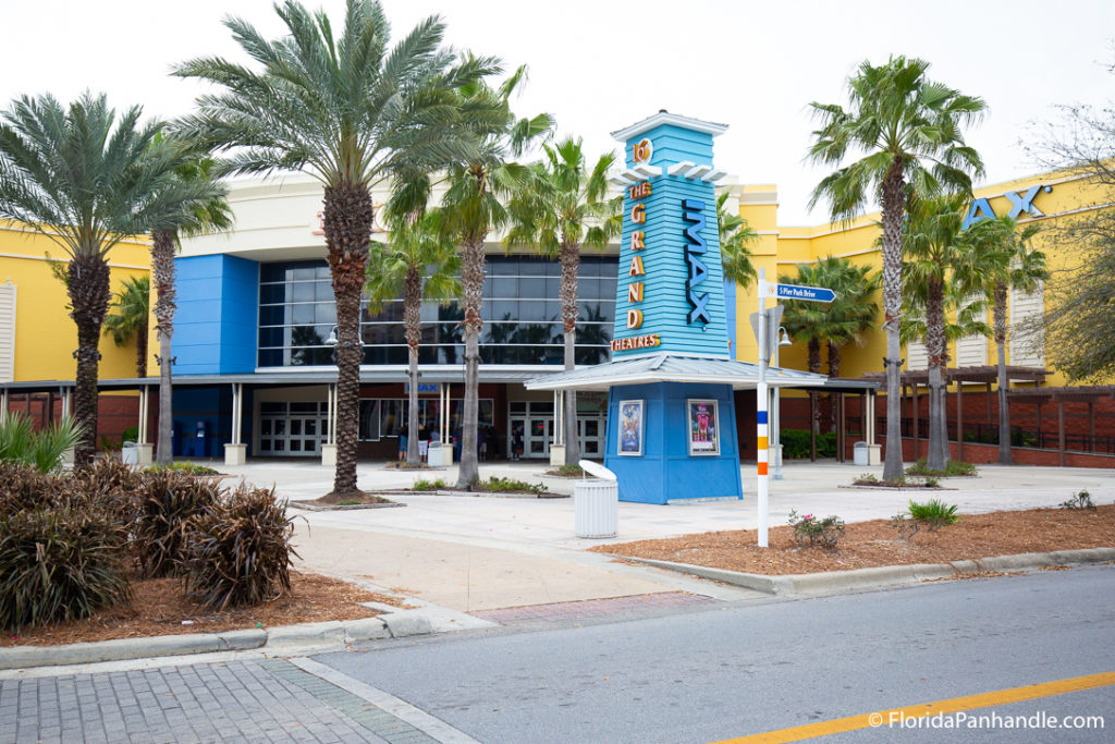 the entrance of a blue and yellow movie theater, pier park, florida