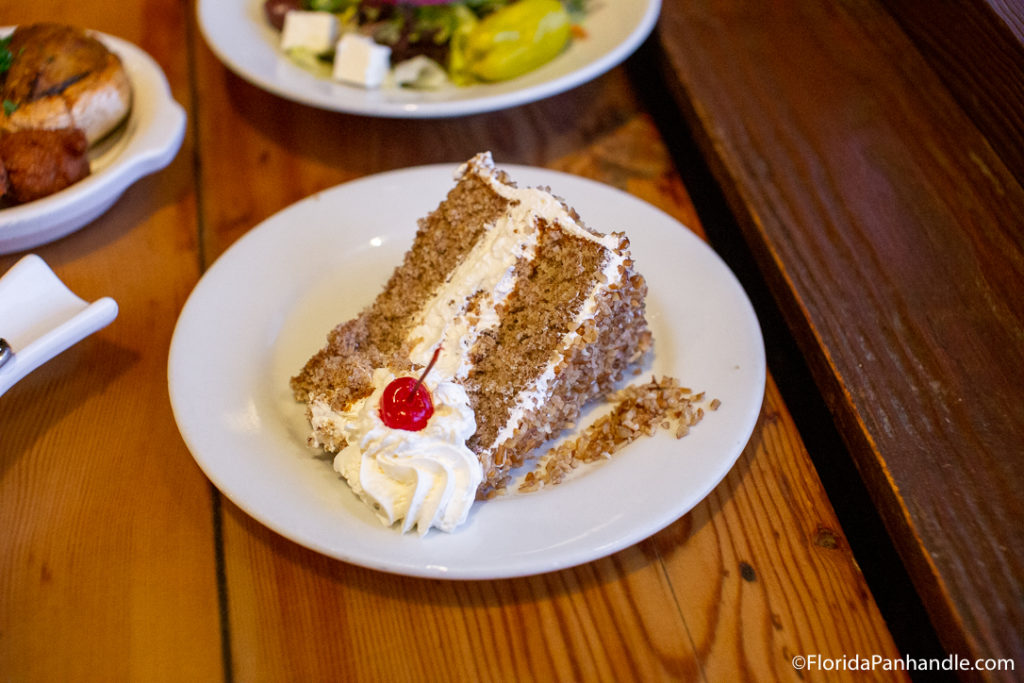 cake dessert with cream in the middle and dollop of cream on side with cherry