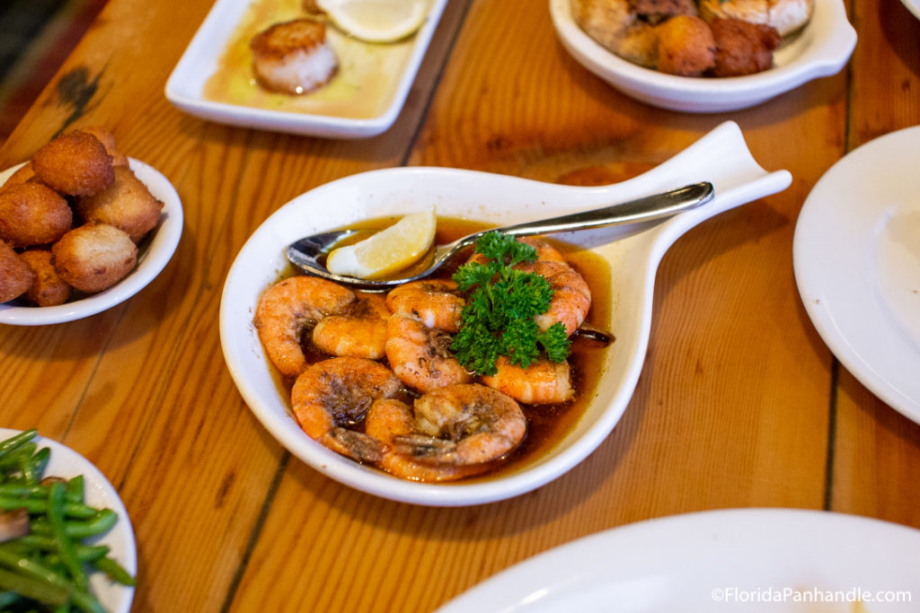 white skillet type plate with shrimp and onions and spoons at capt. andersons