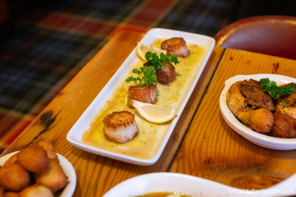 scallops lined up on white plate with lemon at restaurant in florida