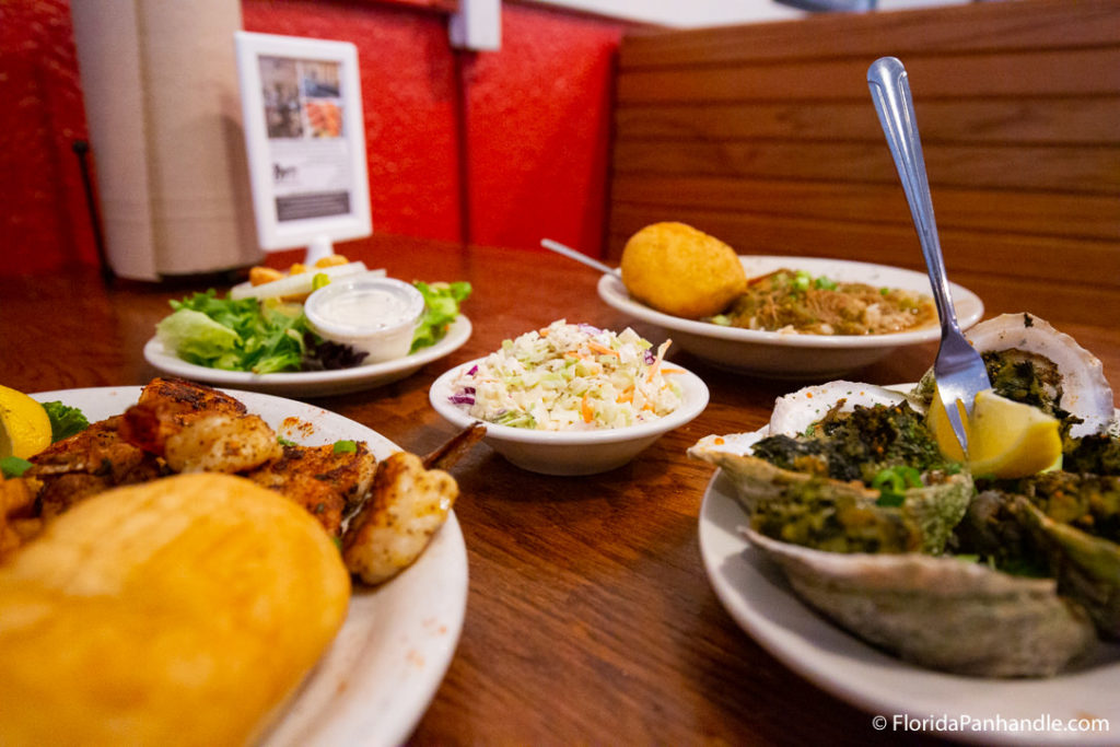 an array of tasty dishes in white plates at bayou on the beach safe, a seafood restaurant in florida